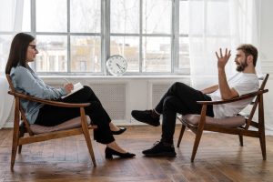 Homem conversando com psicóloga em uma sala